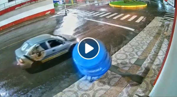 Na falta de guarda-chuva, homem usa caixa d'água para se "proteger"