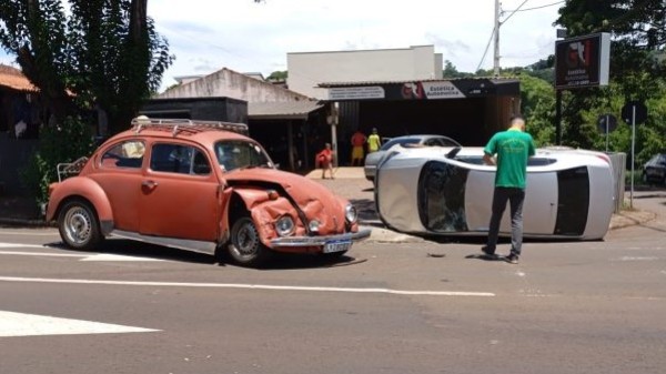 Colisão entre Fusca e Voyage deixa veículo tombado